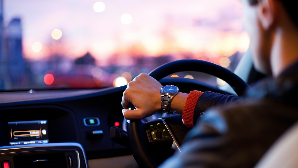 Uomo alla guida di un auto britannica